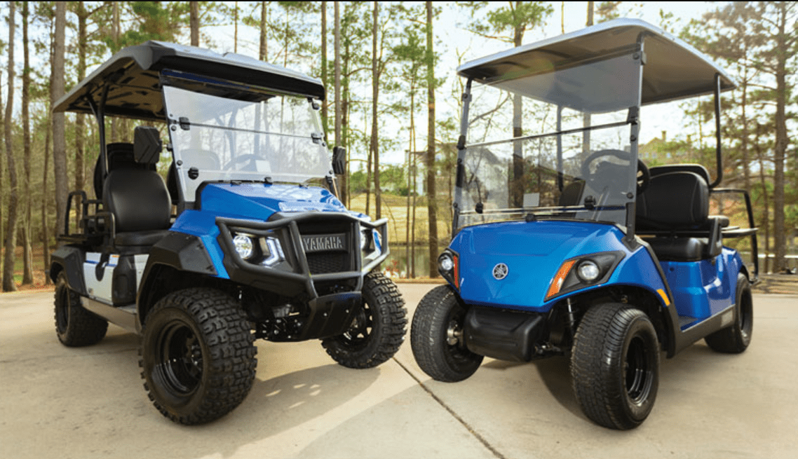 Two blue off-road utility vehicles parked side by side.
