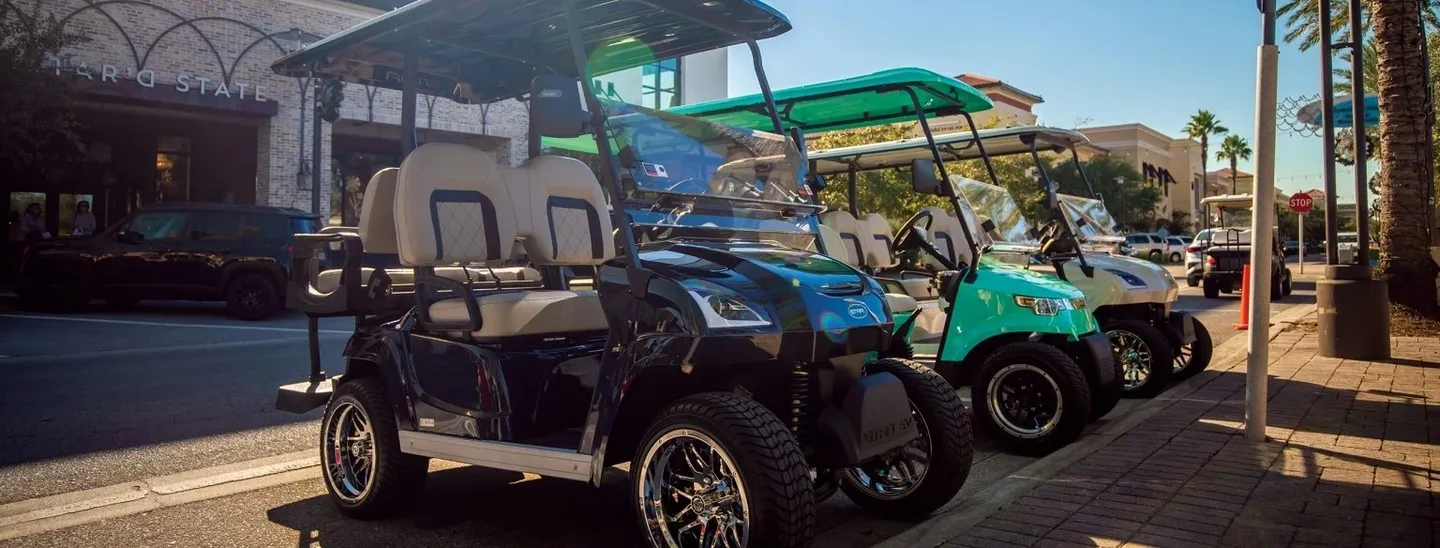 Two golf carts parked side by side outdoors.