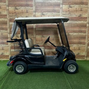 Black golf cart parked indoors on turf
