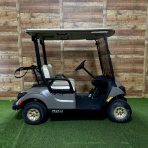 Silver golf cart parked indoors on turf